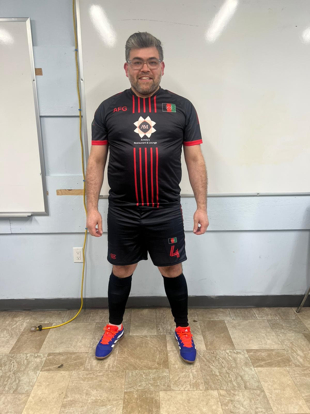 A smiling player from Hamilton Afghan SC before a match